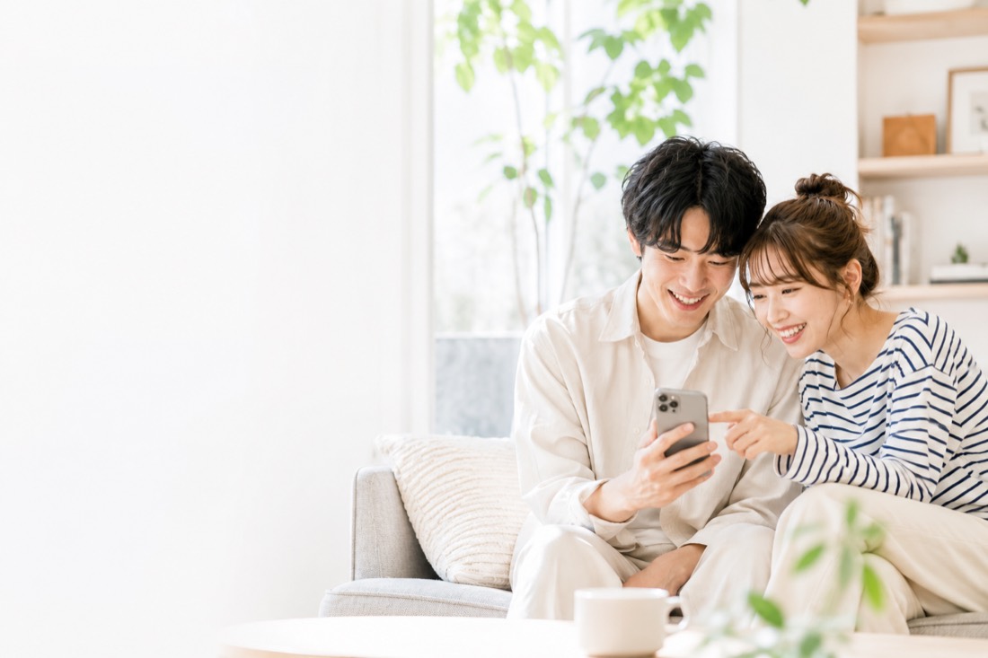ソファでスマホを見ながら式場をさがすふたり